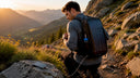 Hiker with solar backpack charging phone outdoors