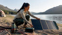 Camper adjusting foldable solar panel at forest campsite