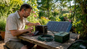 Person connecting solar panels to power station outdoors