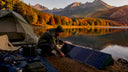 Man adjusting solar panels at mountain campsite