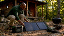 Man setting up solar generator at campsite