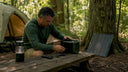 Man setting up portable camping power station outdoors