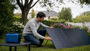Man adjusting solar panels on rooftop at dawn